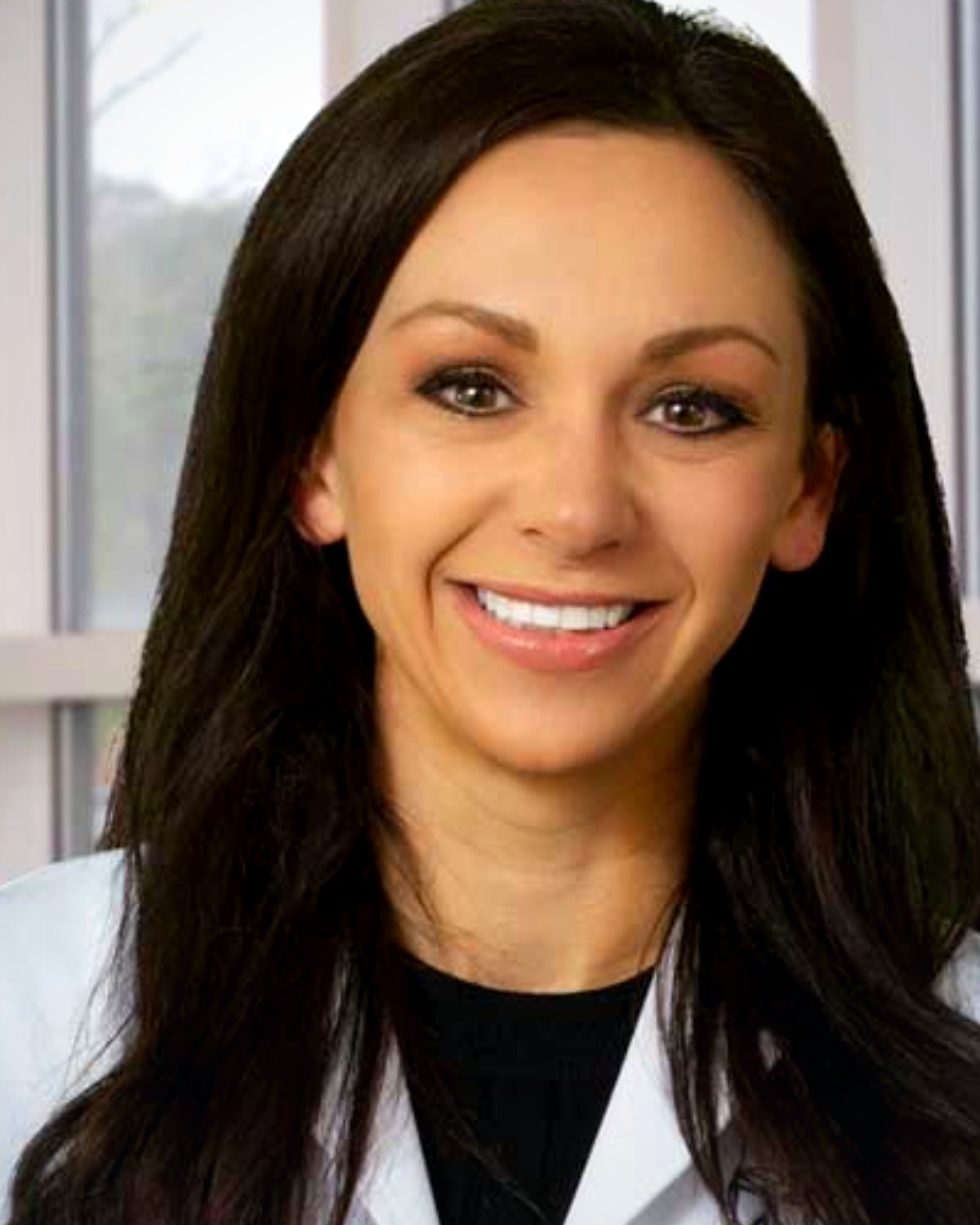 Portrait of Emily Ray, DO, smiling, wearing a white coat
